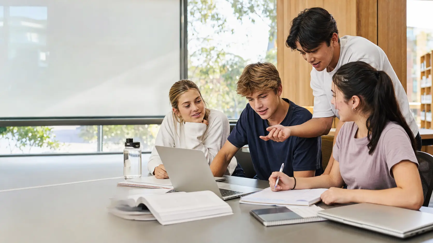 Four senior students studying together in a contemporary school library